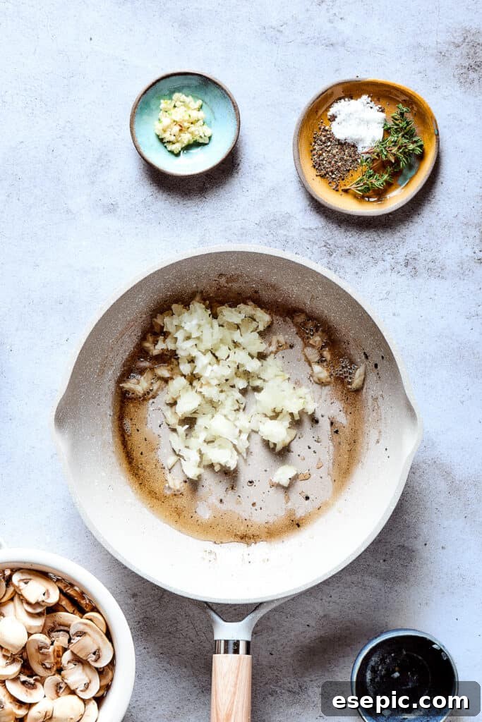 Butter melting in a skillet with chopped onions beginning to caramelize.