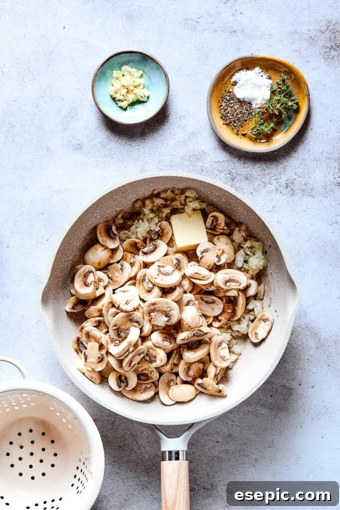 Sliced mushrooms being added to the skillet with sautéed onions for the gravy.