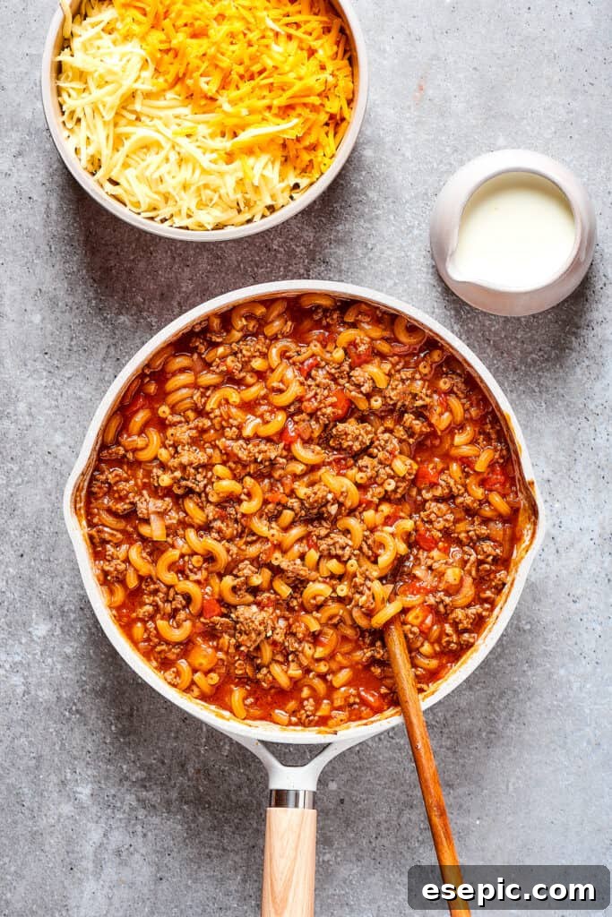 Elbow macaroni cooking to tender perfection directly in the savory beef and tomato sauce.