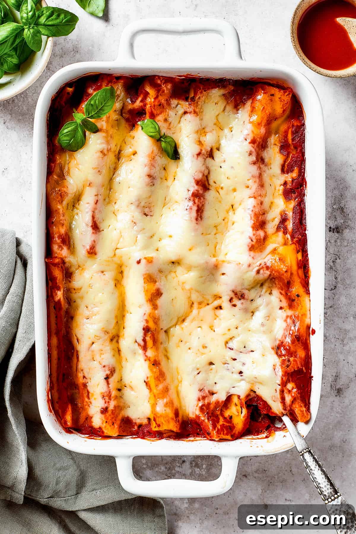 A beautifully baked pasta dish garnished with fresh basil, ready to be served.