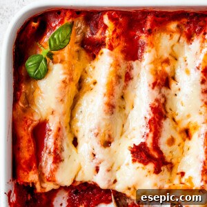 Close-up of baked manicotti that has been cut into and served.