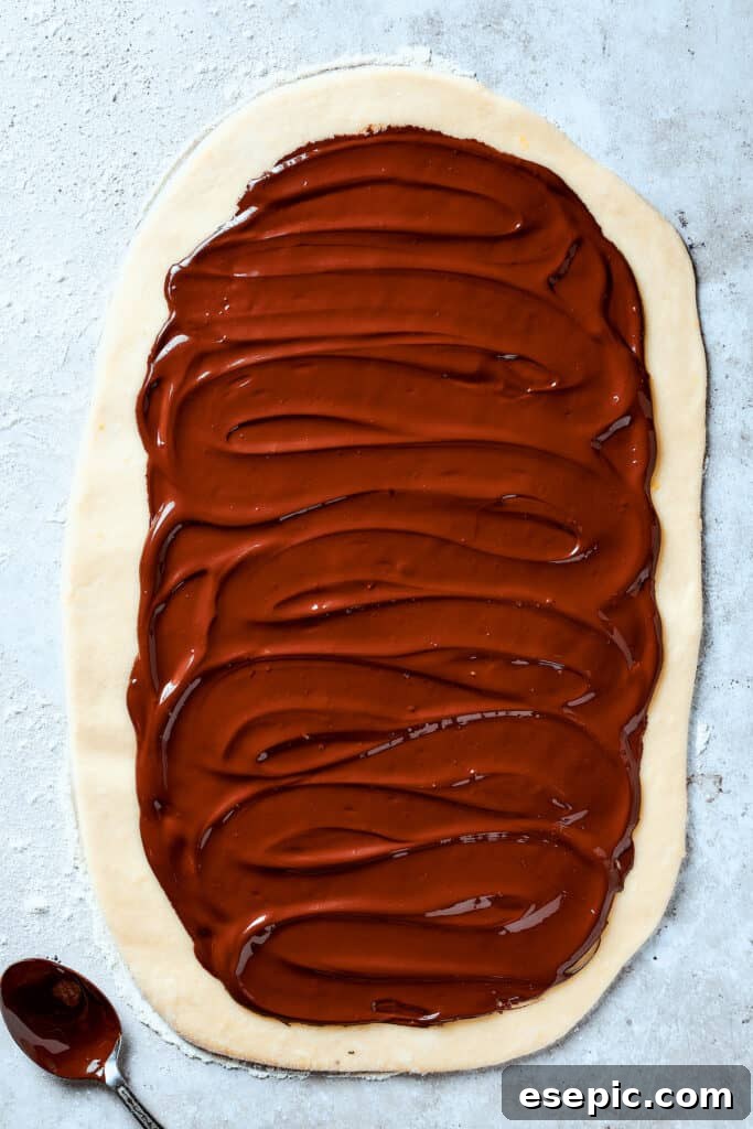 Sweet, puffy Chocolate Babka is an old-fashioned yeast bread swirled with layers of chocolate. Perfect for a special breakfast or dessert. Chocolate spread out over a rectangle of dough.