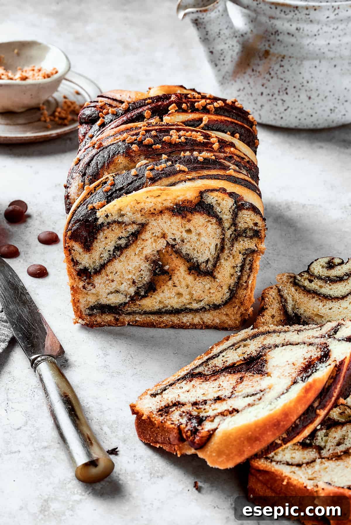 Chocolate Babka - Traditional Chocolate Swirl Bread! A side view of a sliced chocolate babka, with several slices artfully arranged in front of the main loaf.