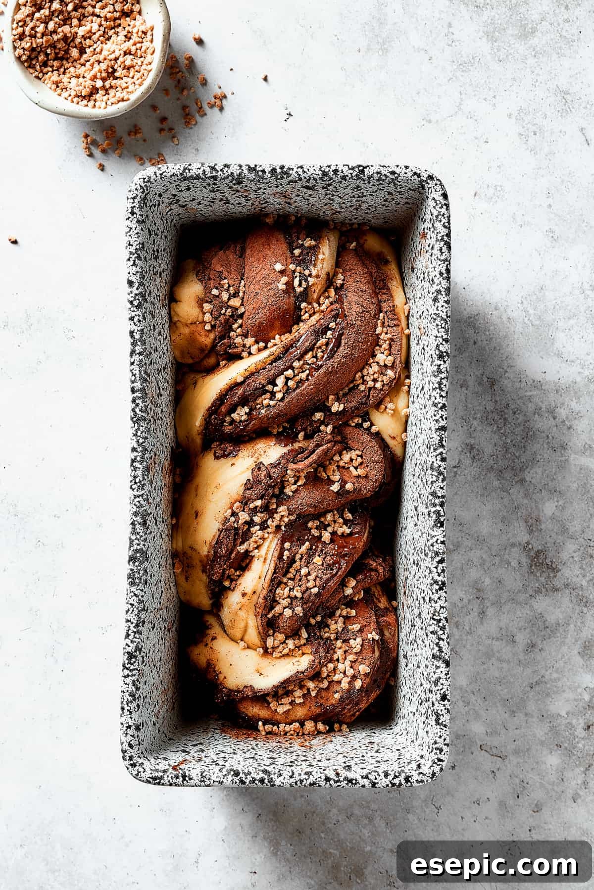 Sweet, puffy Chocolate Babka is an old-fashioned yeast bread swirled with layers of chocolate. Perfect for a special breakfast or dessert. Two halves of chocolate-filled dough twisted together, ready to be baked in a loaf pan.
