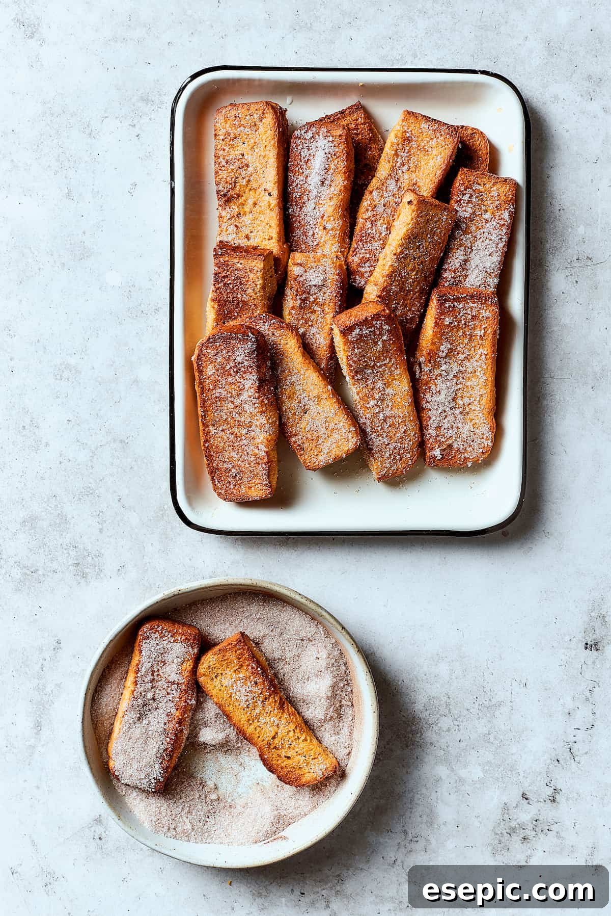 Rolling French toast sticks in cinnamon sugar.