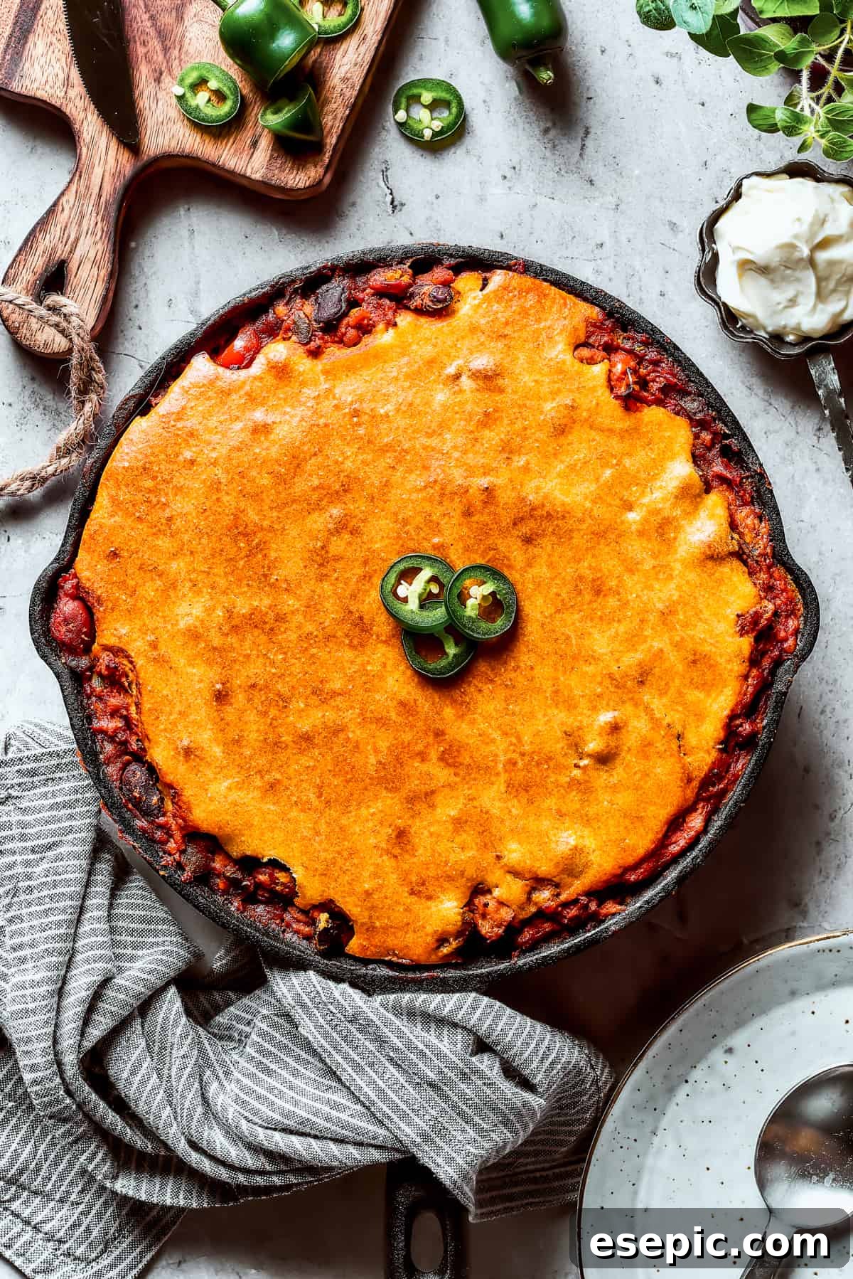 Chili with cornbread baked on top, garnished with jalapenos.