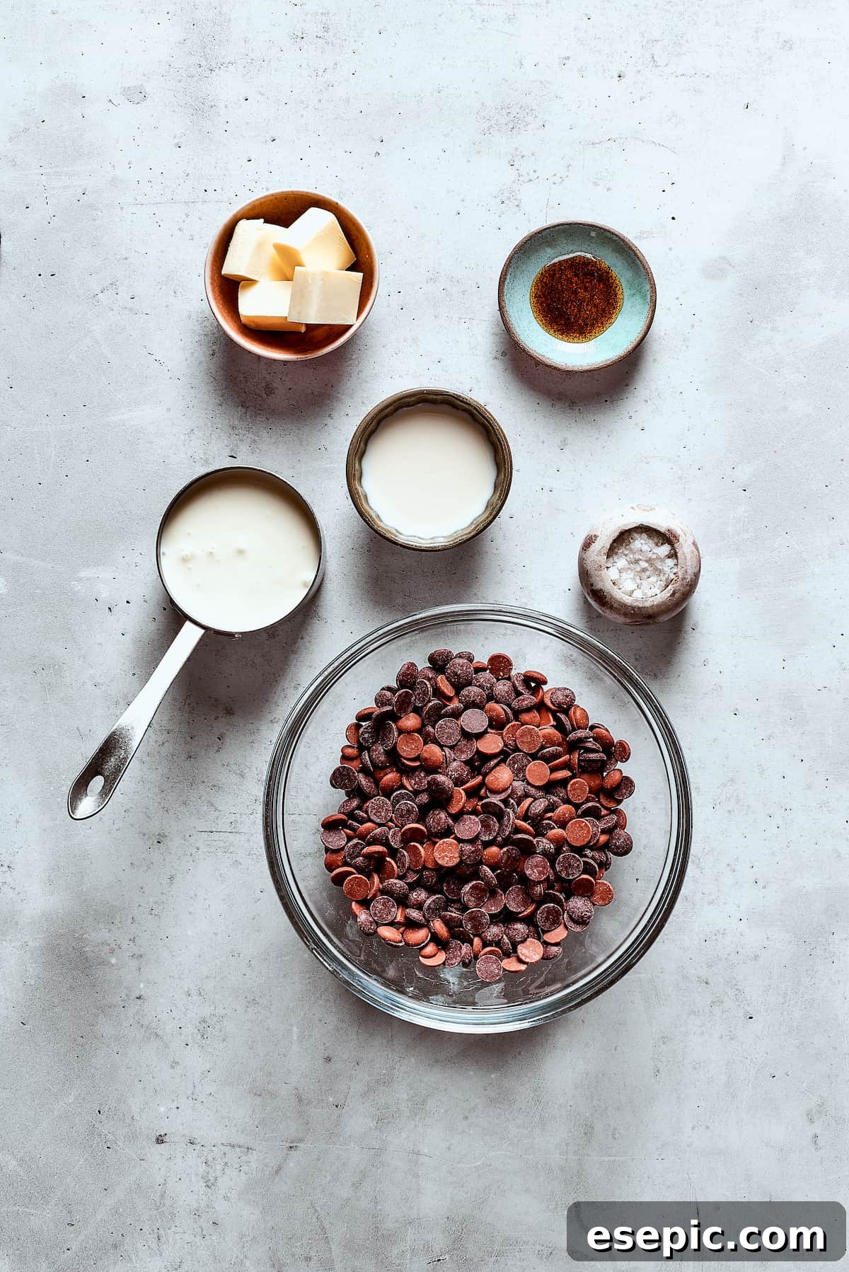 Precisely measured chocolate fondue ingredients laid out on a table, including chopped chocolate, cream, butter, and vanilla.