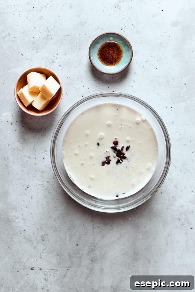 A bowl filled with finely chopped chocolate and warm cream, ready to be stirred into fondue.