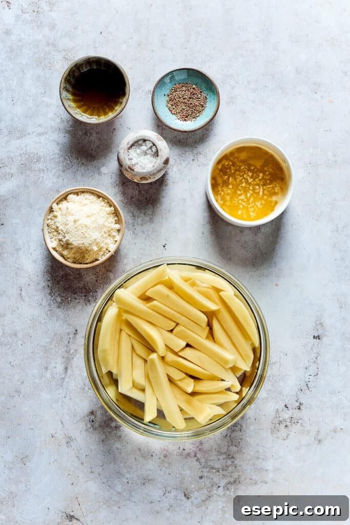Cut fries soaking in water, with other ingredients in dishes on the work surface.