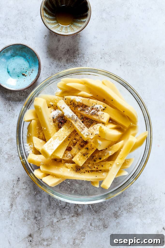 Seasoning the uncooked fries.