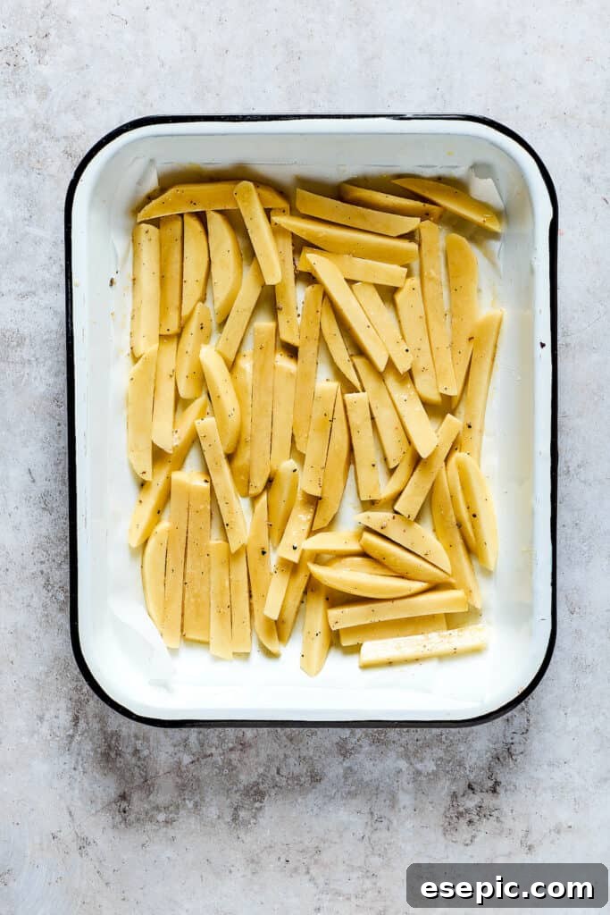 Unbaked fries in a baking dish.