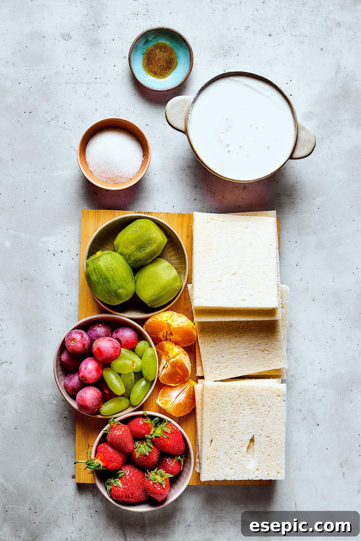 Ingredients for homemade fruit sando measured and arranged on a work surface, including bread, cream, sugar, and various fruits.