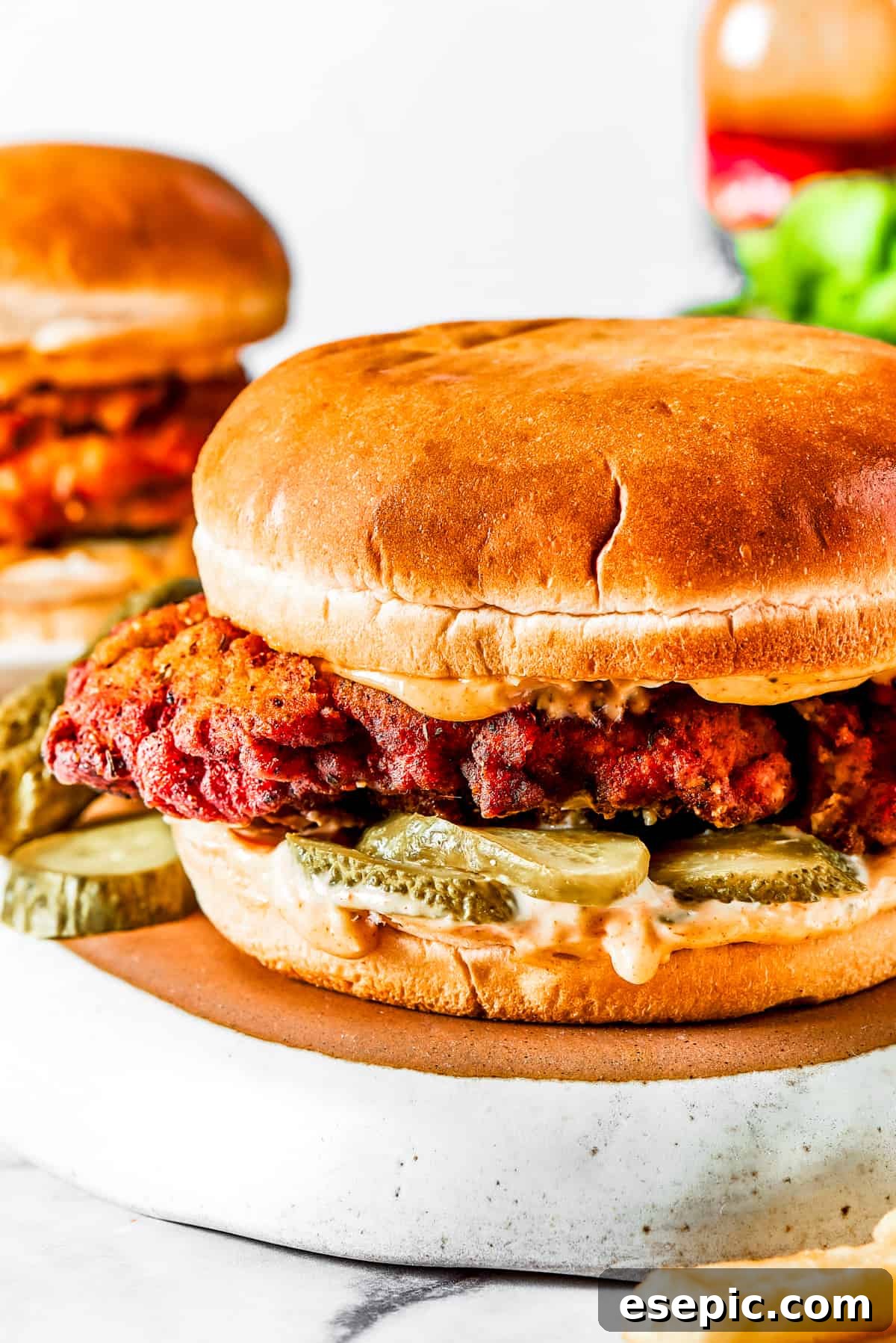 Crispy and juicy Copycat KFC Chicken Sandwich Close-up shot of a perfectly golden-brown, crispy fried chicken sandwich on a soft bun, garnished with pickles.