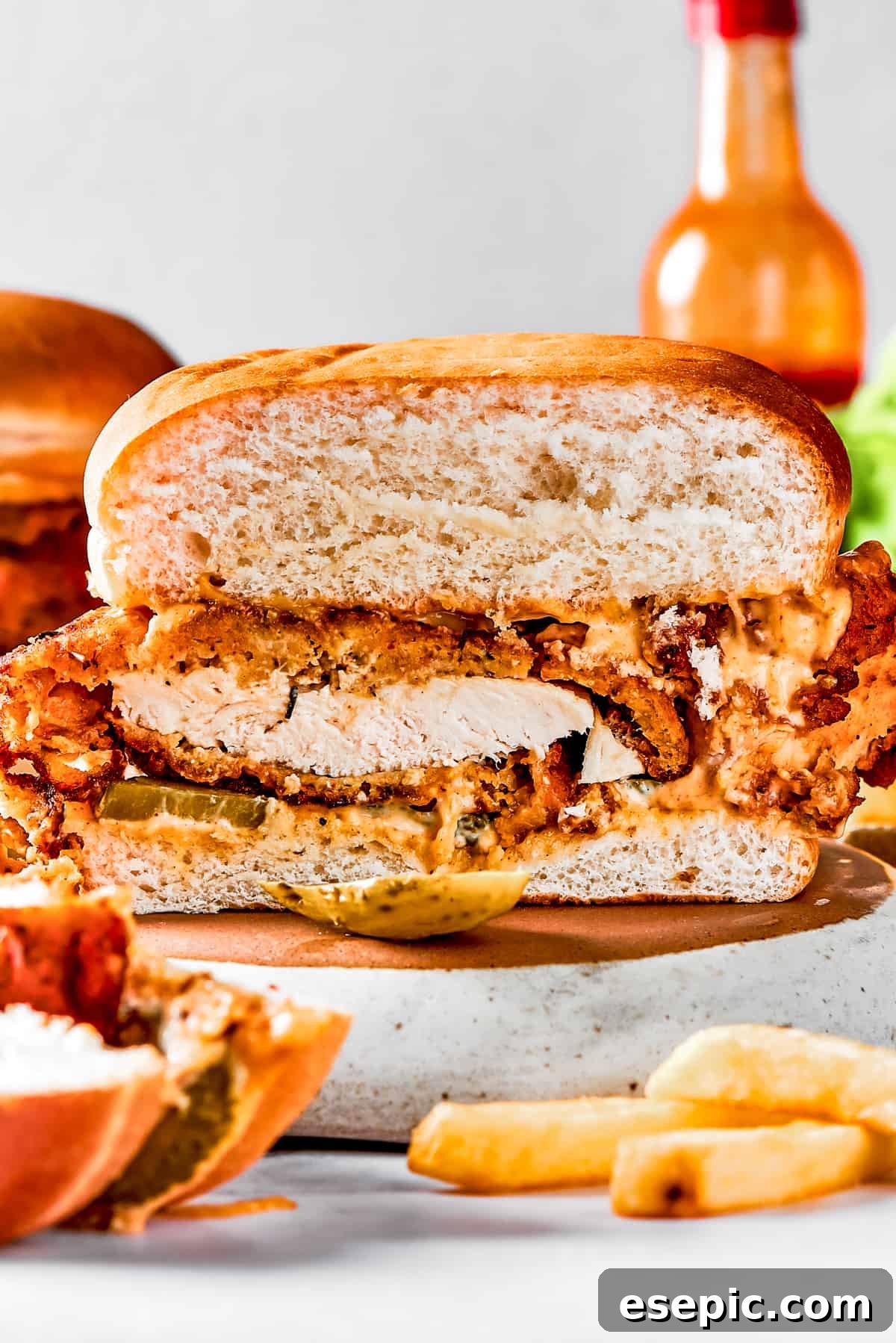 Sliced fried chicken sandwich for serving A homemade fried chicken sandwich, expertly cut in half to display its juicy interior and crispy coating.