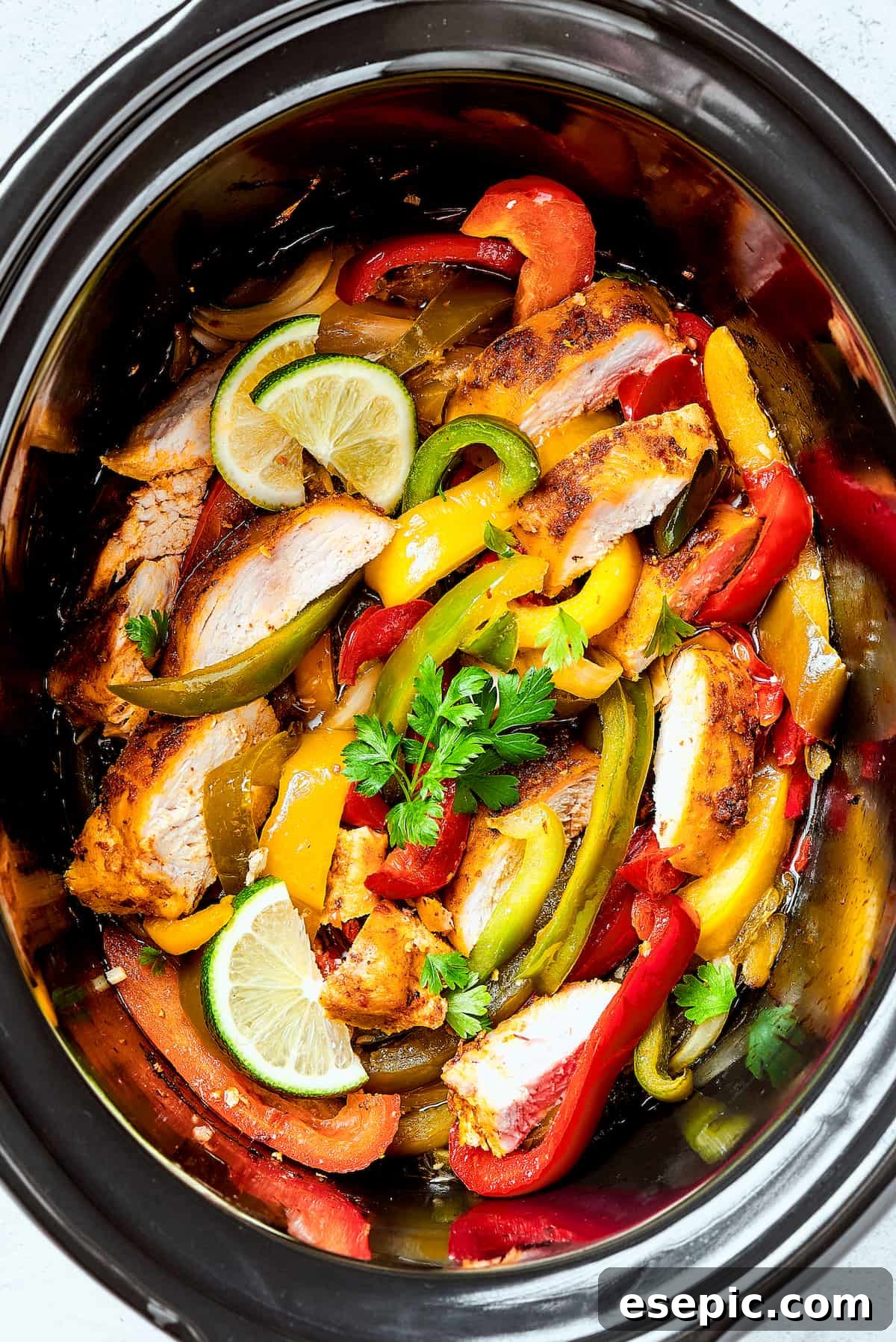 Crockpot chicken fajitas in a slow cooker insert.