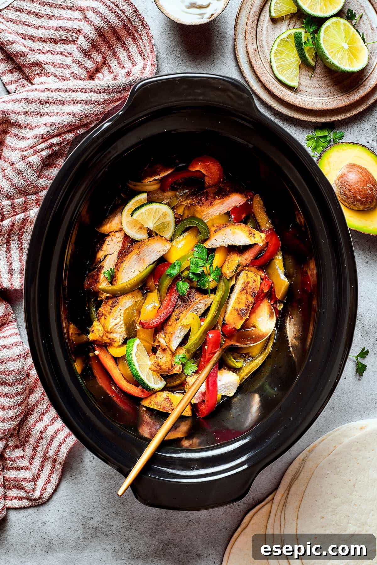 A slow cooker of Southwest-style chicken with bell peppers and onions.