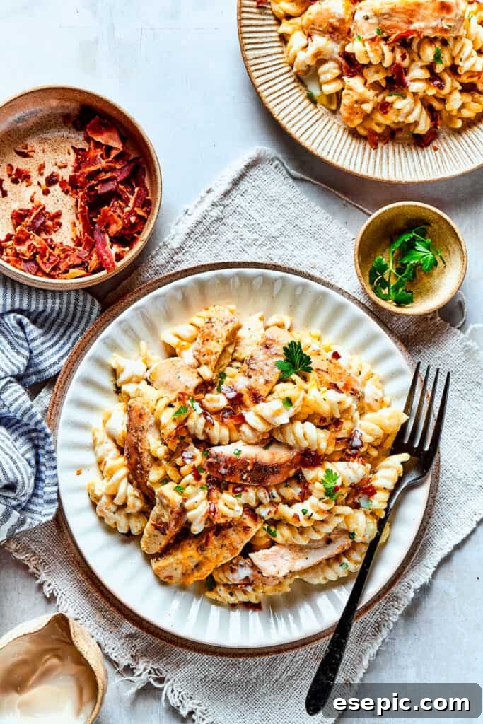 An inviting overhead view of two plates of creamy Chicken Bacon Ranch Pasta, garnished and ready to be enjoyed.