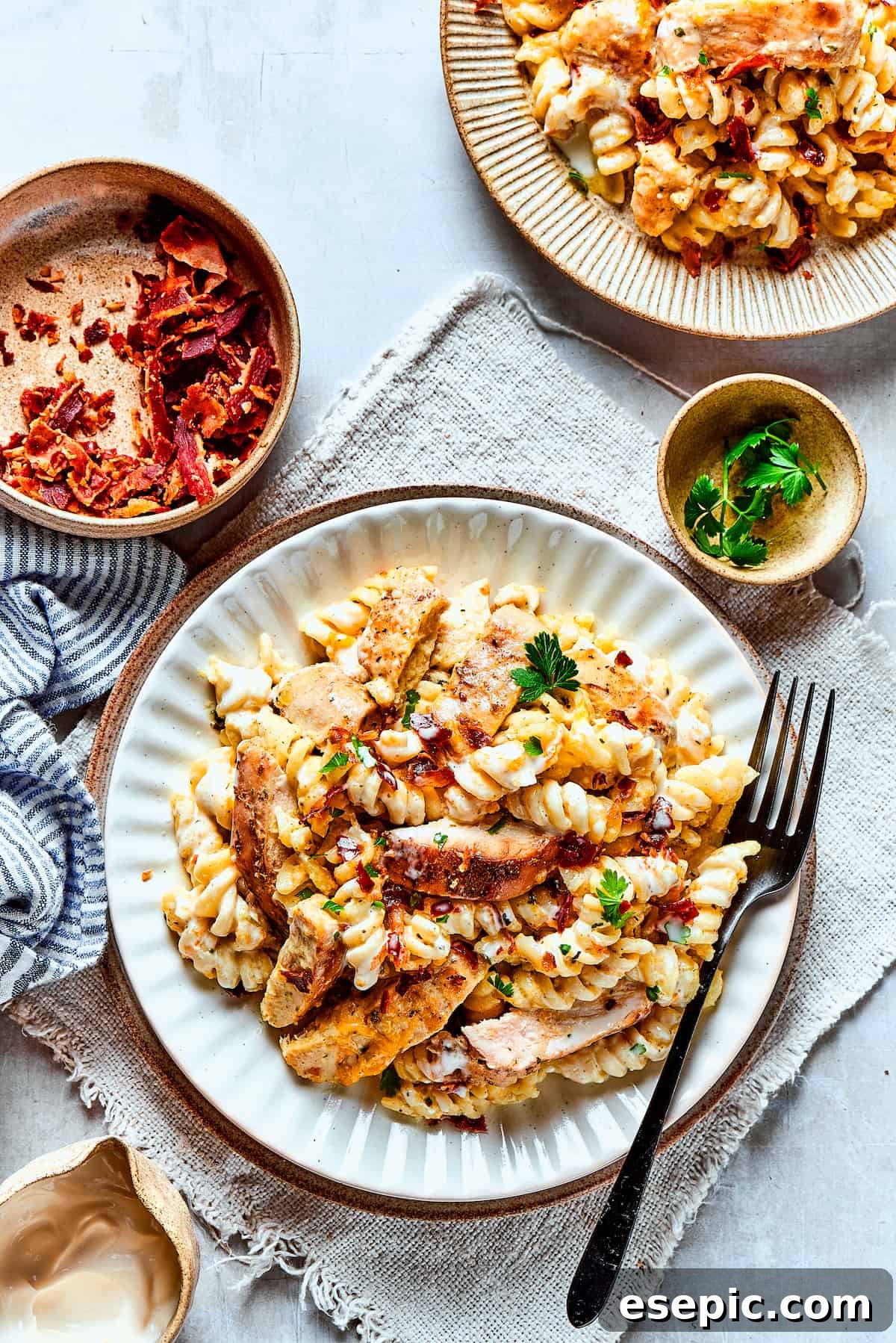 An inviting overhead view of two plates of creamy Chicken Bacon Ranch Pasta, garnished and ready to be enjoyed.