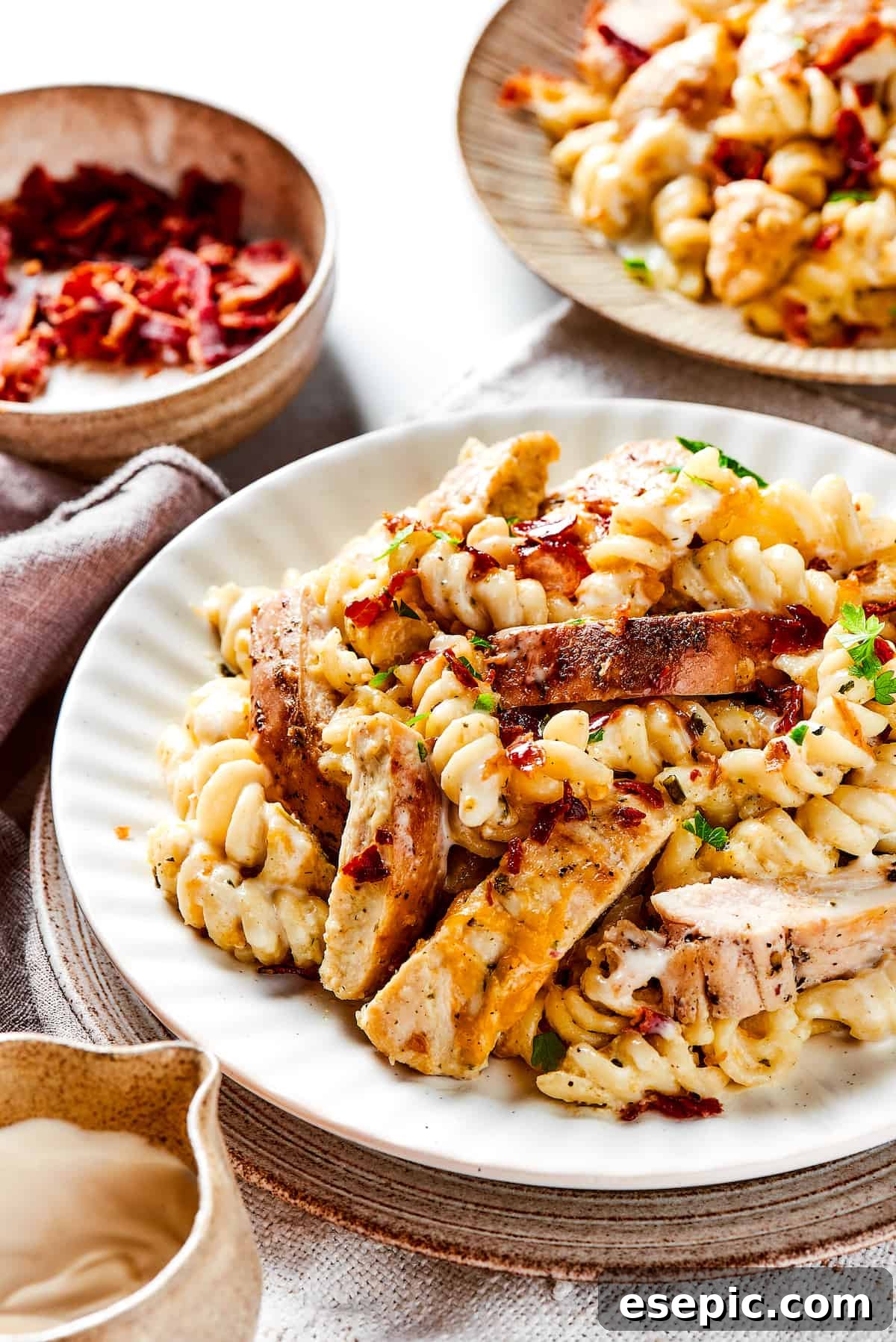 Two dinner plates filled with savory Chicken Bacon Ranch Pasta, ready to be served for a cozy meal.