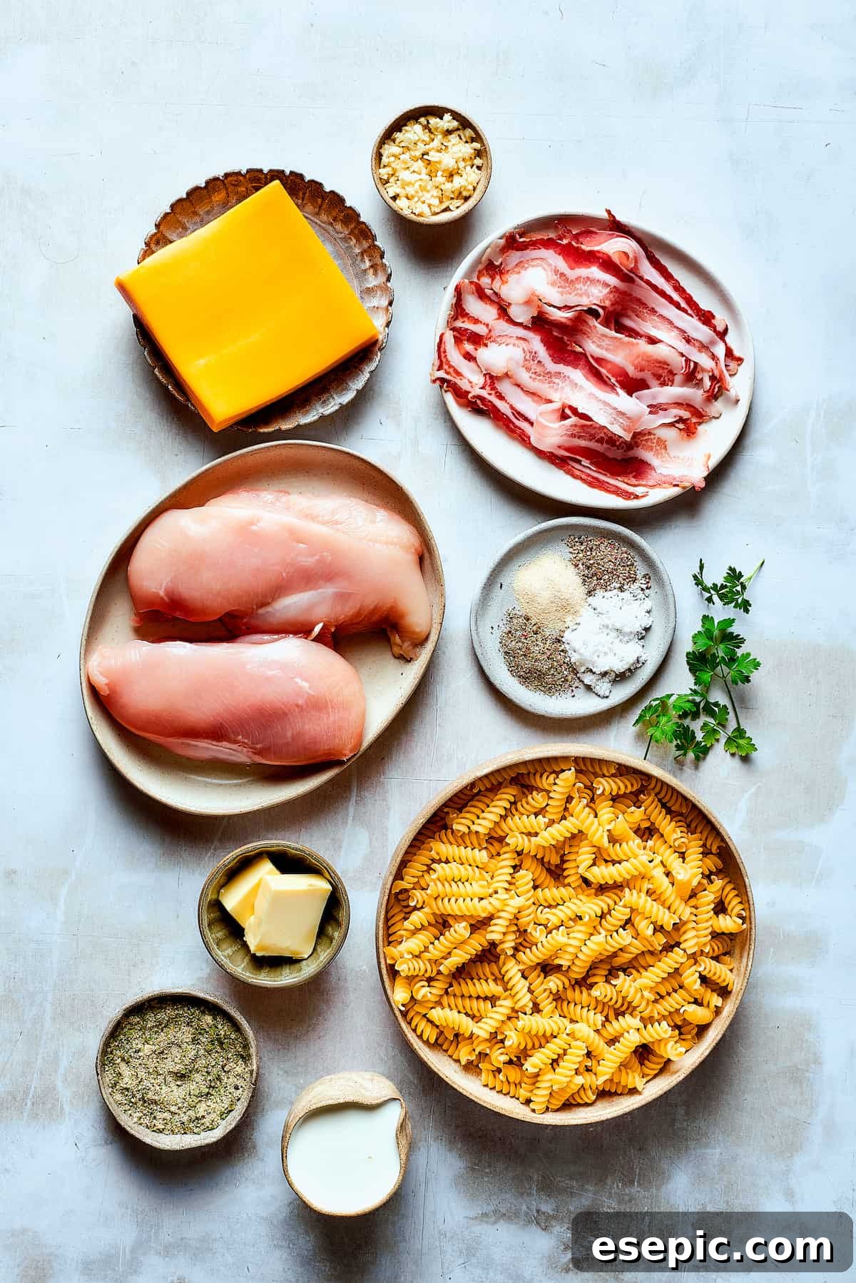 A vibrant arrangement of all the fresh ingredients for Chicken Bacon Ranch Pasta, carefully measured and ready for cooking on a clean white surface.