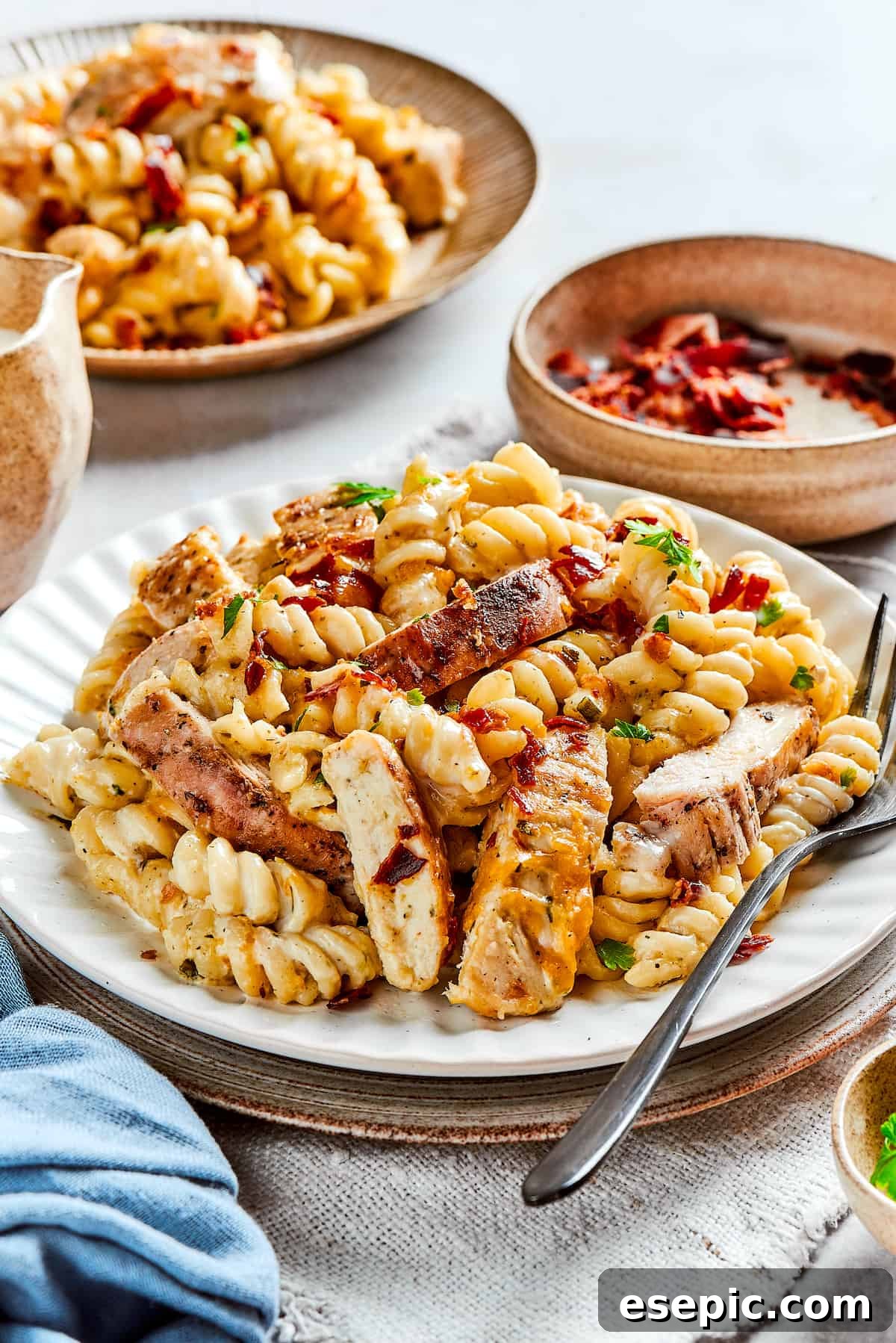 Individual portions of creamy Chicken Bacon Ranch Pasta served on white dinner plates.