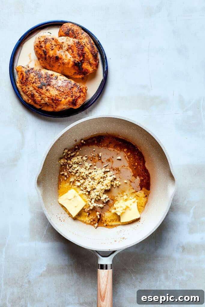 Unsalted butter and minced garlic sizzling in a hot skillet, ready for the creamy sauce.