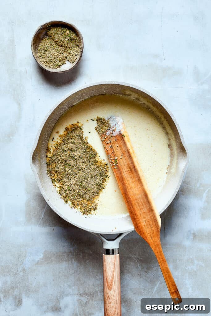 Rich, creamy sauce simmering in a skillet, thickened to perfection for pasta.