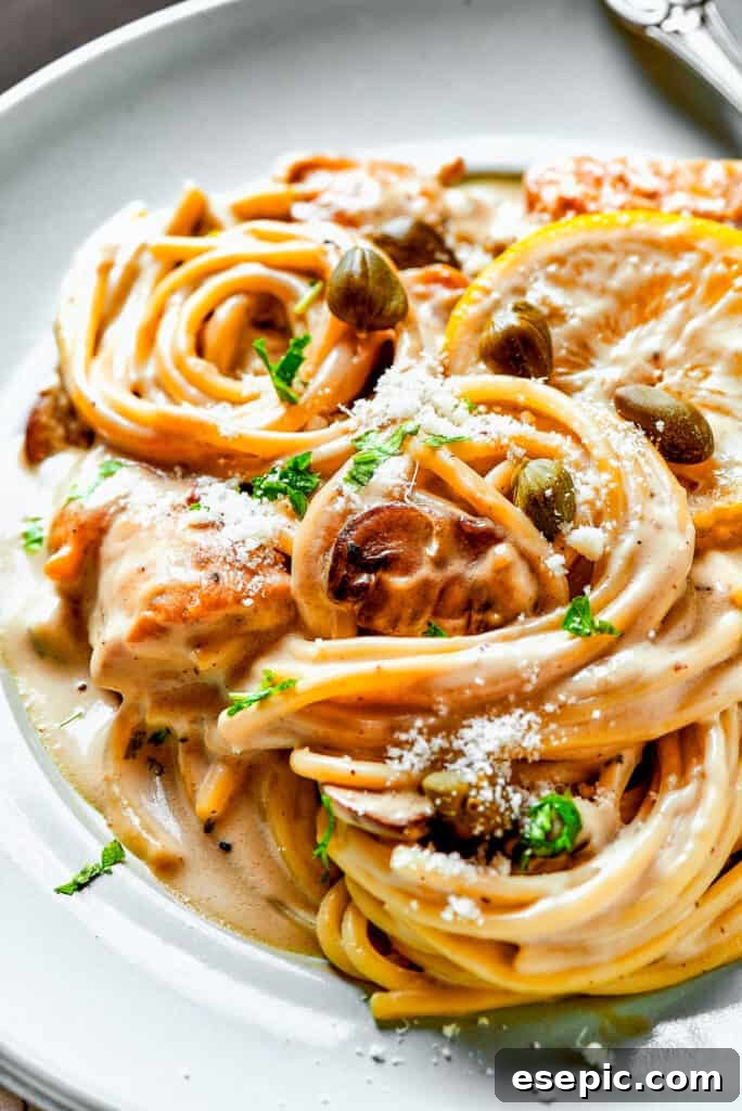 A close-up view of creamy chicken piccata pasta, featuring tender chicken, capers, and lemon, tossed in a luscious sauce.