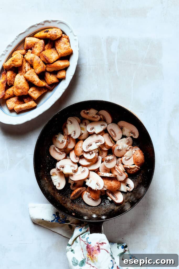 Sliced mushrooms sautéing in a skillet until tender and lightly golden, absorbing residual flavors.
