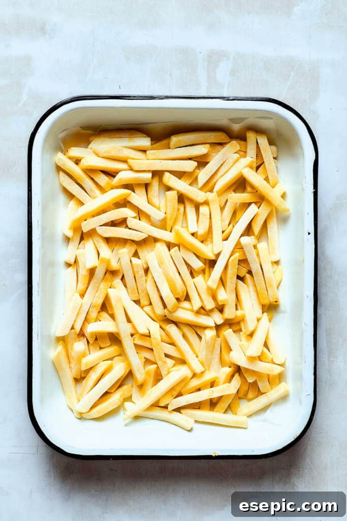 You’ll crave the hot, cheesy goodness of homemade Chili Cheese Fries! This is a fun party appetizer that can double as a family-style meal. Frozen french fries on a baking sheet.