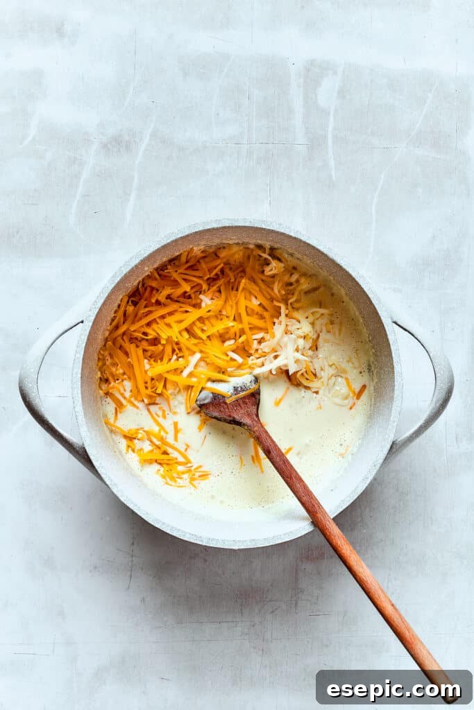 You’ll crave the hot, cheesy goodness of homemade Chili Cheese Fries! This is a fun party appetizer that can double as a family-style meal. Stirring cheddar cheese into a hot cream mixture to make cheese sauce.