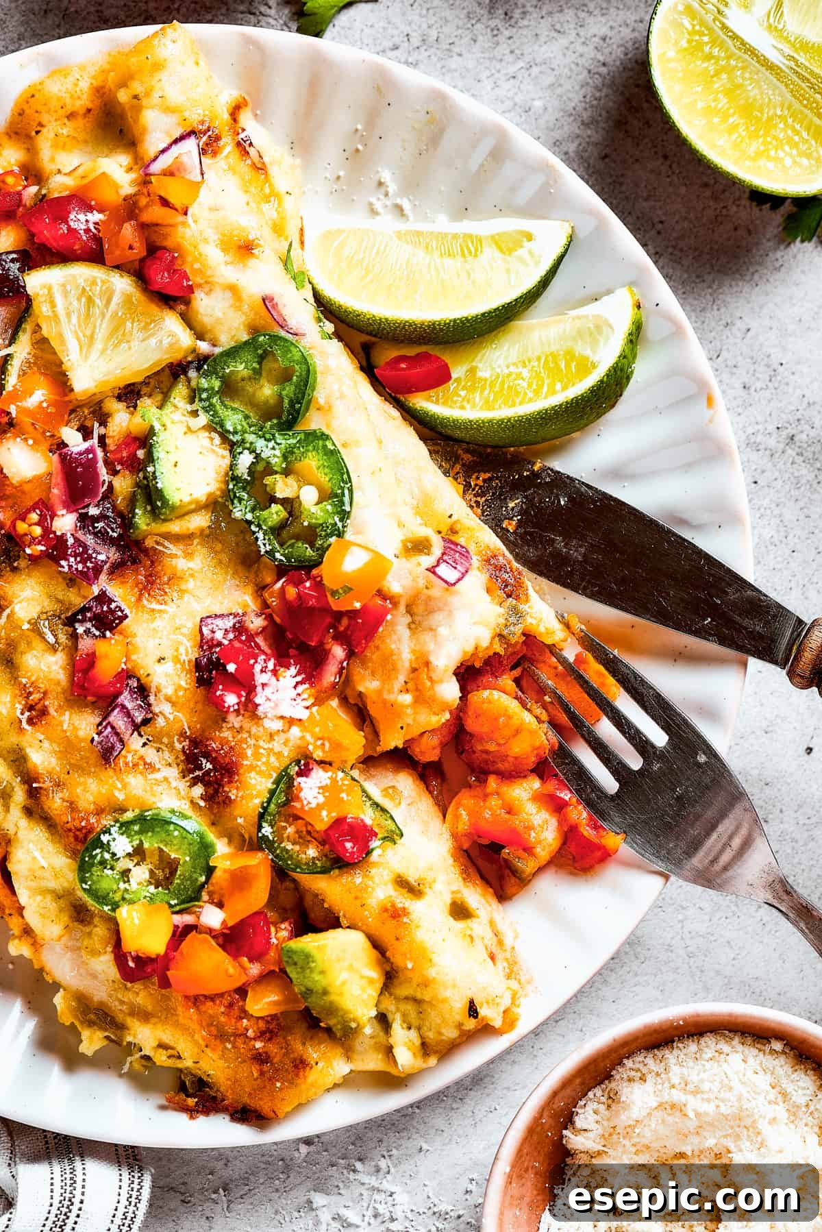 A plate of enchiladas topped with avocado and other toppings.