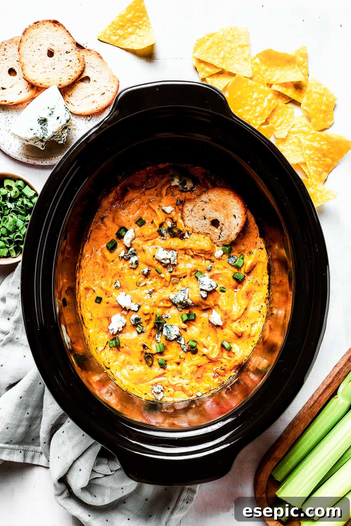 With its creamy, cheesy, spicy goodness, Crockpot Buffalo Chicken Dip is a favorite for parties, game days, movie night, and more! A detailed close-up of a slow cooker insert brimming with a creamy, rich Crockpot Buffalo Chicken Dip, its surface gently bubbling and inviting, showcasing the perfectly melted cheese and integrated ingredients.