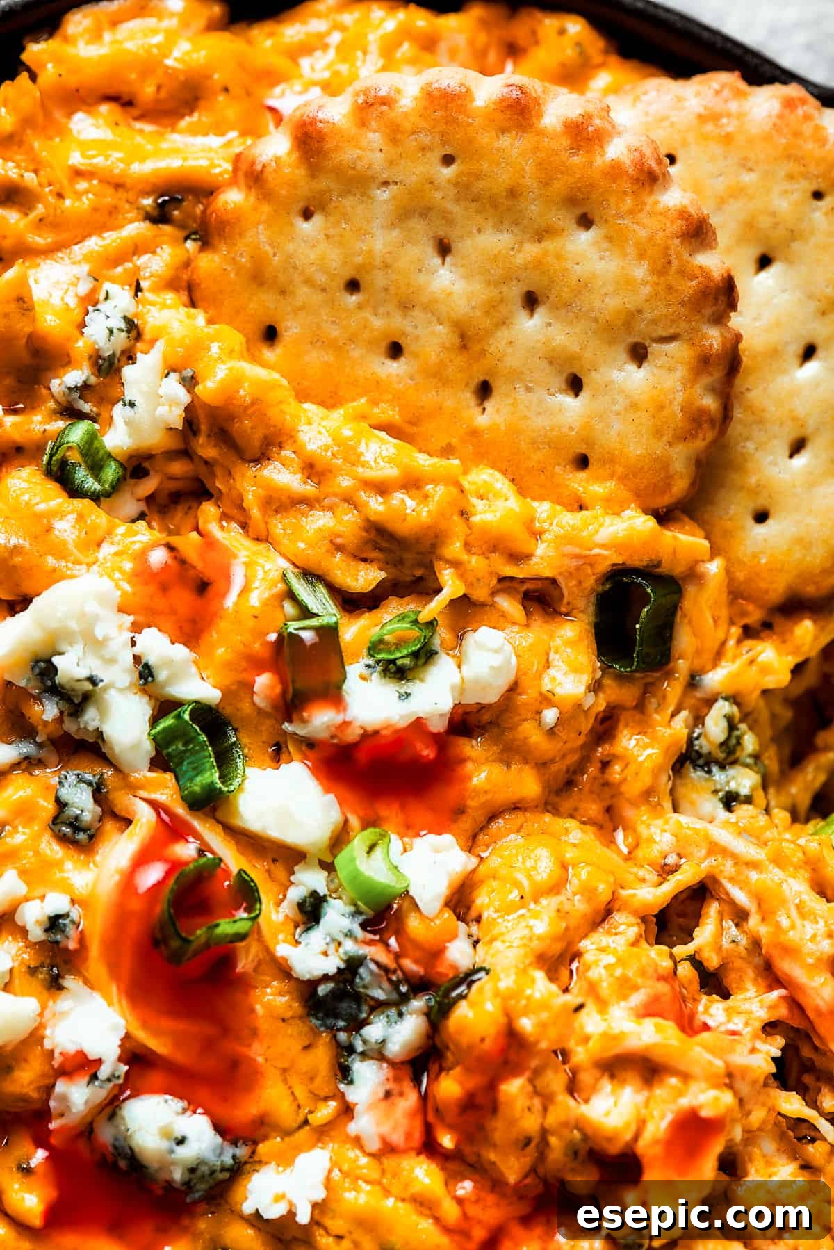 With its creamy, cheesy, spicy goodness, Crockpot Buffalo Chicken Dip is a favorite for parties, game days, movie night, and more! A close-up image showing the rich, creamy texture of Crockpot Buffalo Chicken Dip, with golden crackers dipped in, highlighting its inviting consistency and delicious appeal.