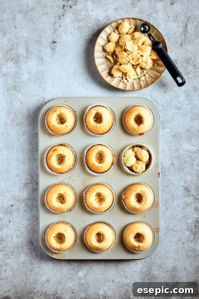Decadent Banana Pudding Cupcakes 14 A tray of baked cupcakes with their centers precisely cored out, ready to be filled with creamy banana pudding.