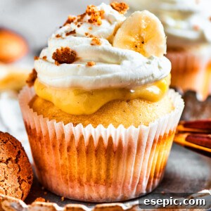 One banana pudding cupcake on a dessert plate. More cupcakes are in the background of the shot.
