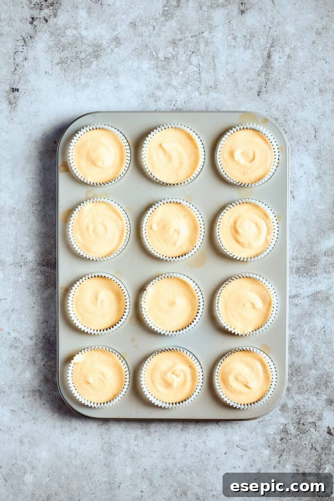 Decadent Banana Pudding Cupcakes 8 Unbaked cupcake batter neatly scooped into paper liners, ready for the oven in a cupcake pan.