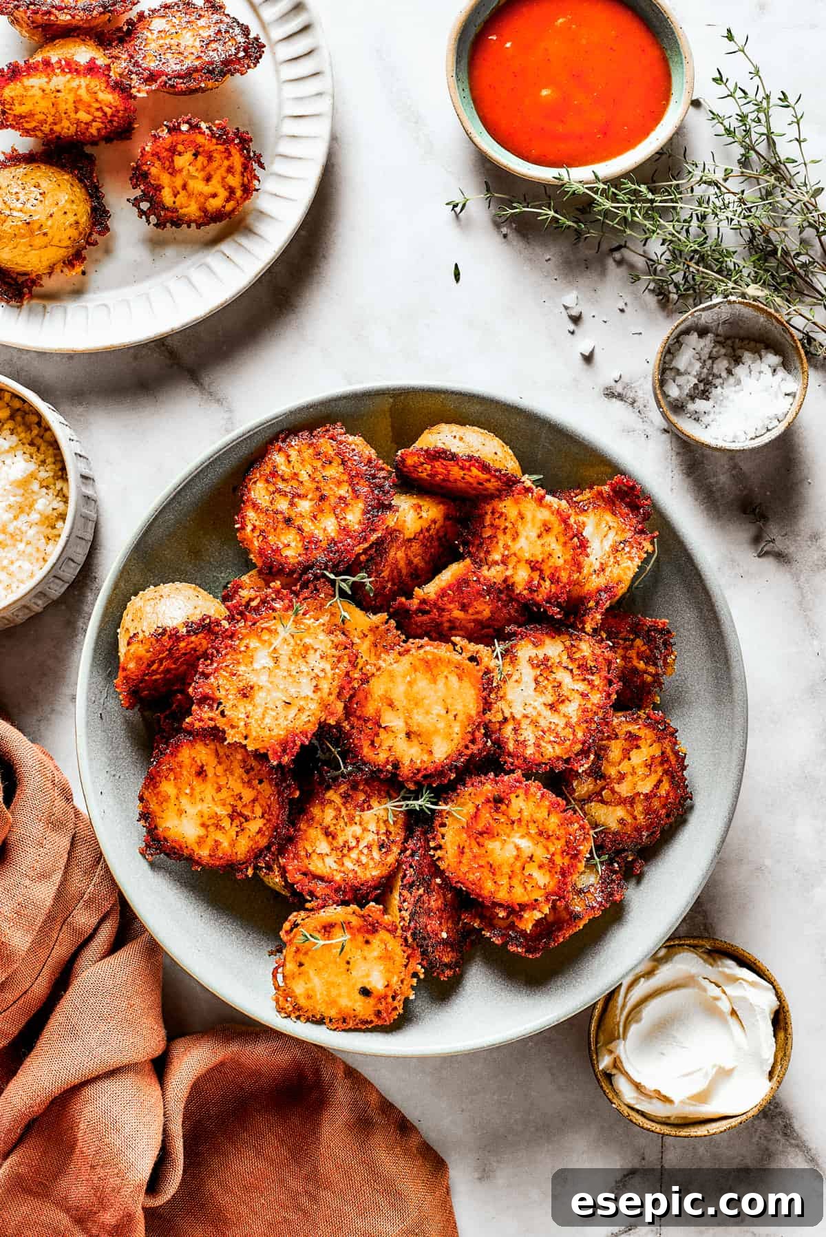 A bowl of baked potato halves crusted with parmesan cheese, ready to be served.
