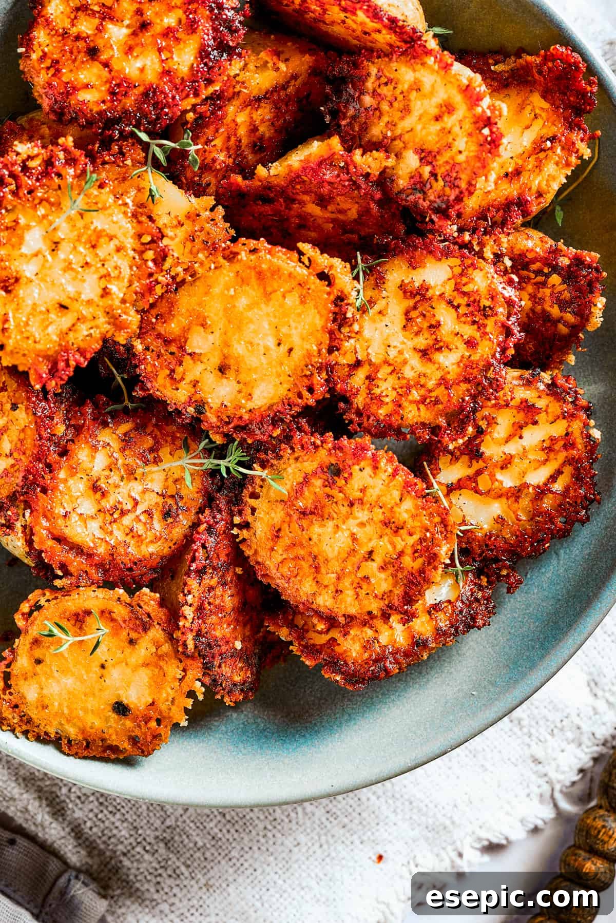 Close-up of parmesan-crusted potatoes in a bowl, showing the crisp texture and golden color.