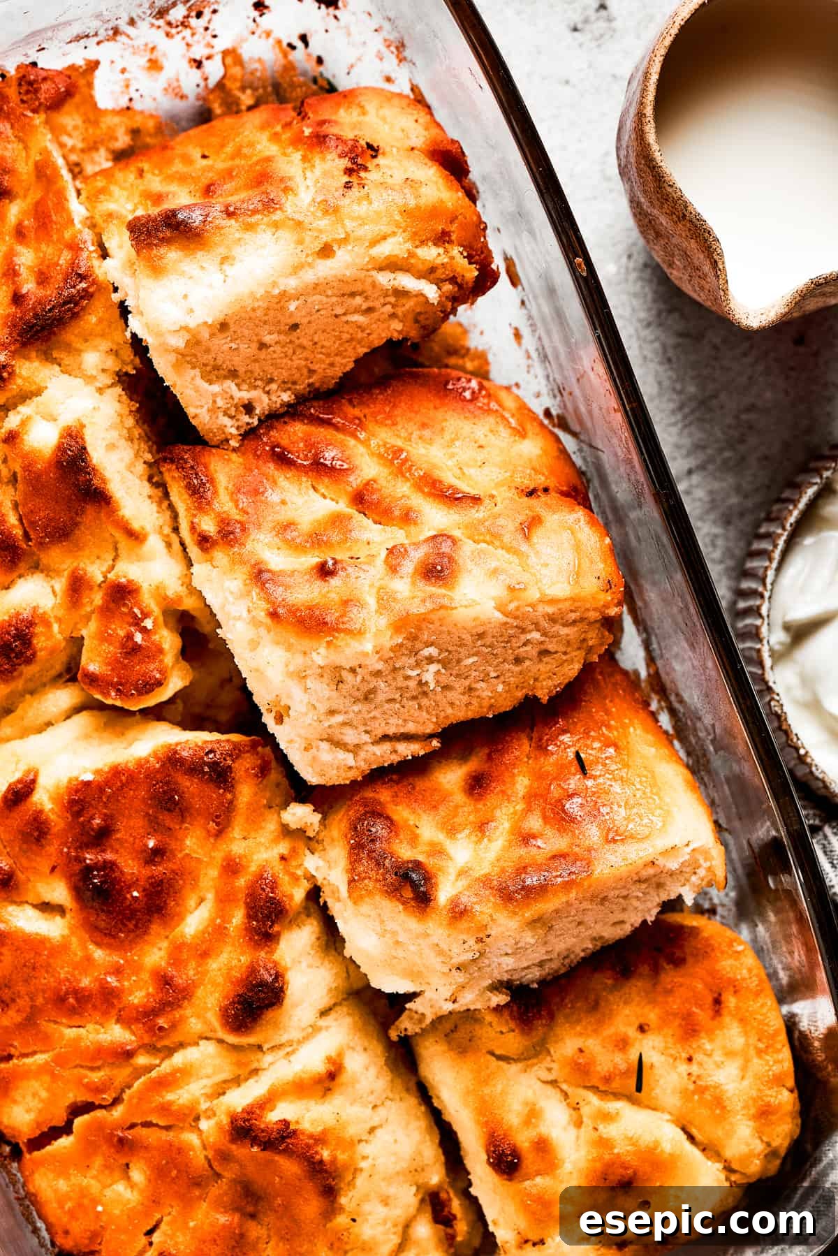 A pan with butter swim biscuits, with a few cut out and stacked on each other, showing their internal texture.