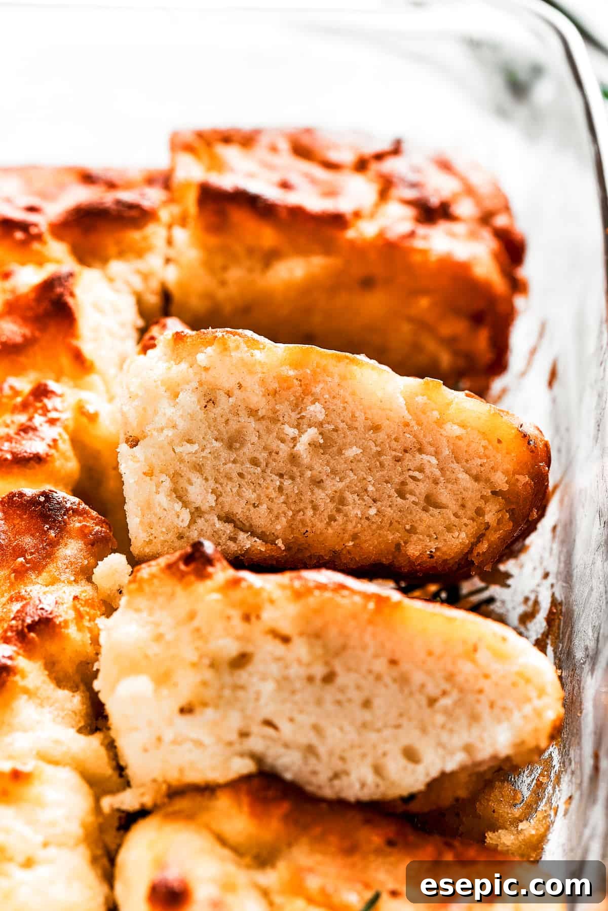 A pan with butter swim biscuits, with a few cut out and stacked on each other, displaying their tempting golden-brown crust.