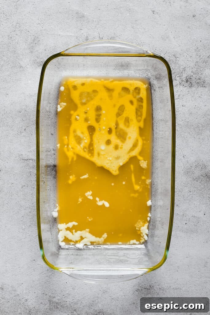A rectangular baking dish with melted butter in it, ready for the biscuit dough.