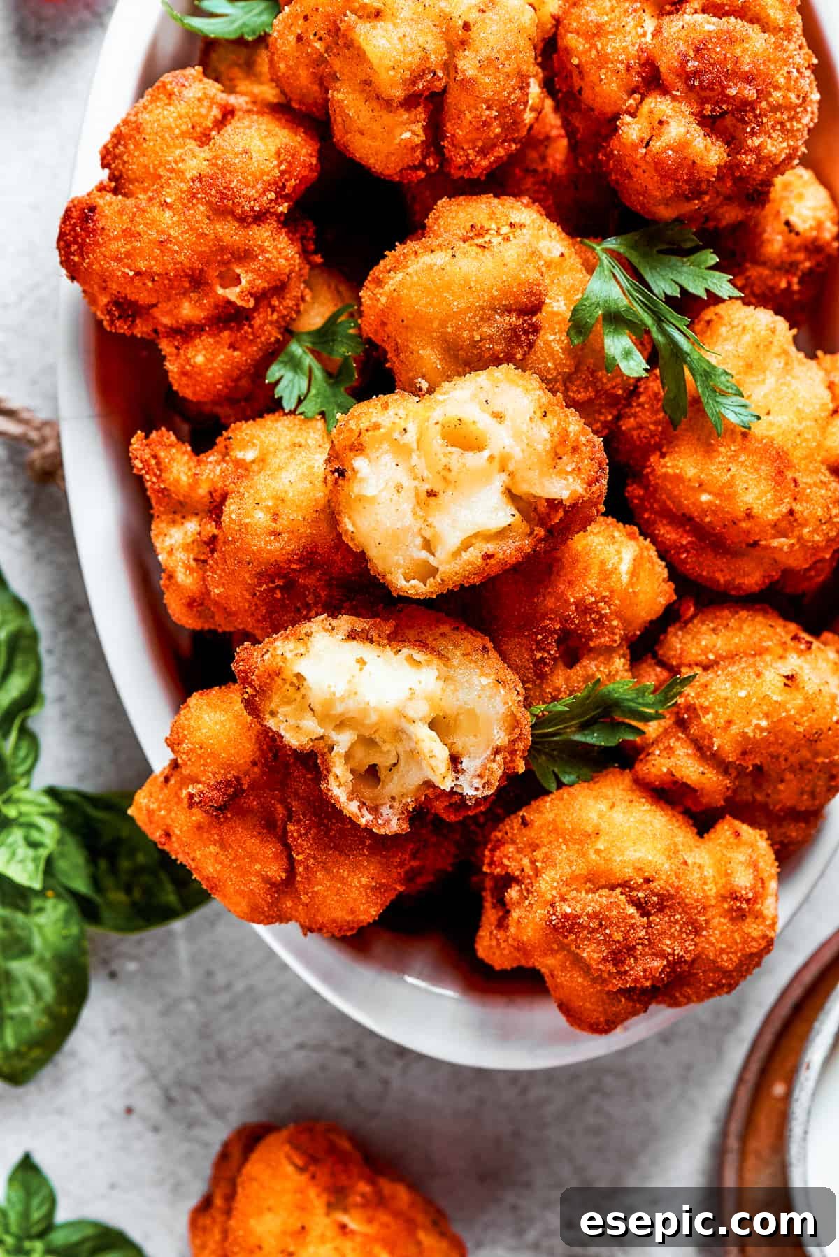 Overhead view of fried mac and cheese bites with one pulled apart.