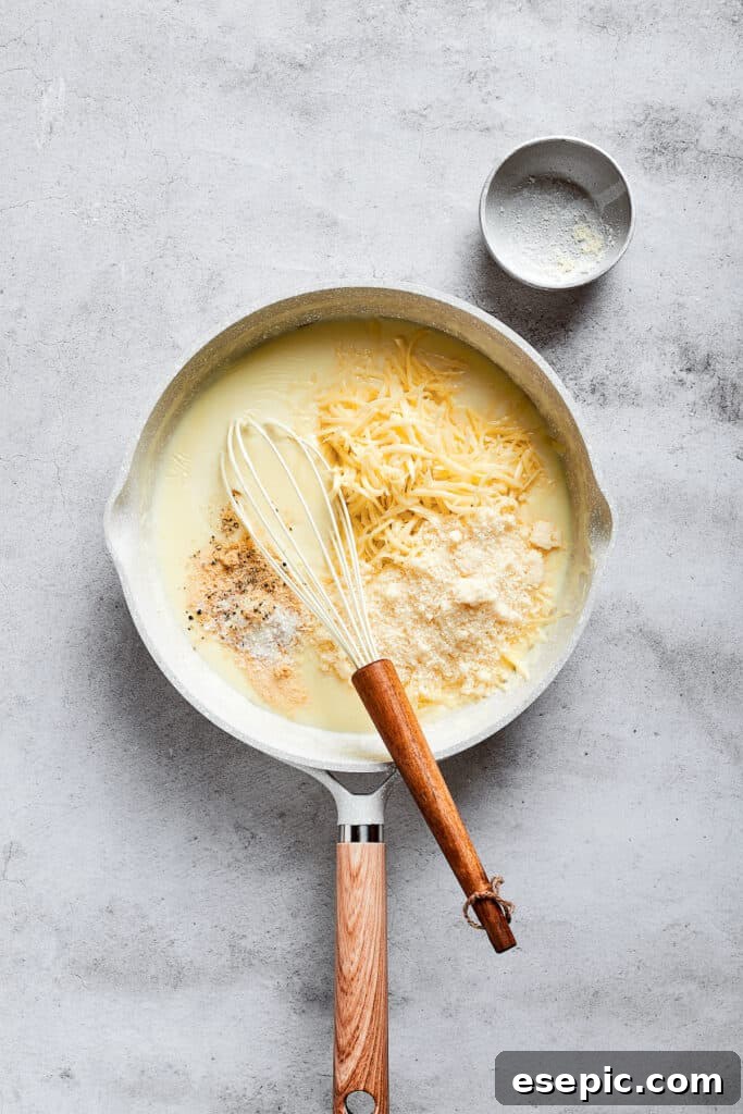 A sauce pan with a whisk and shredded cheese on top of milk.