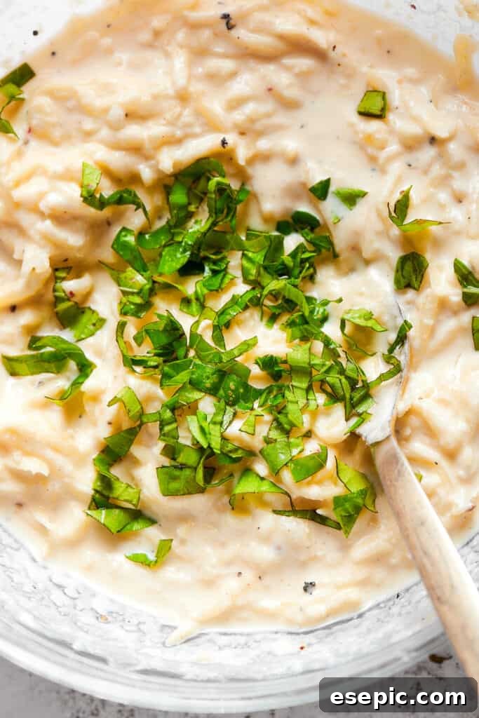 Close up overhead view of basil being mixed into a cheese filling.