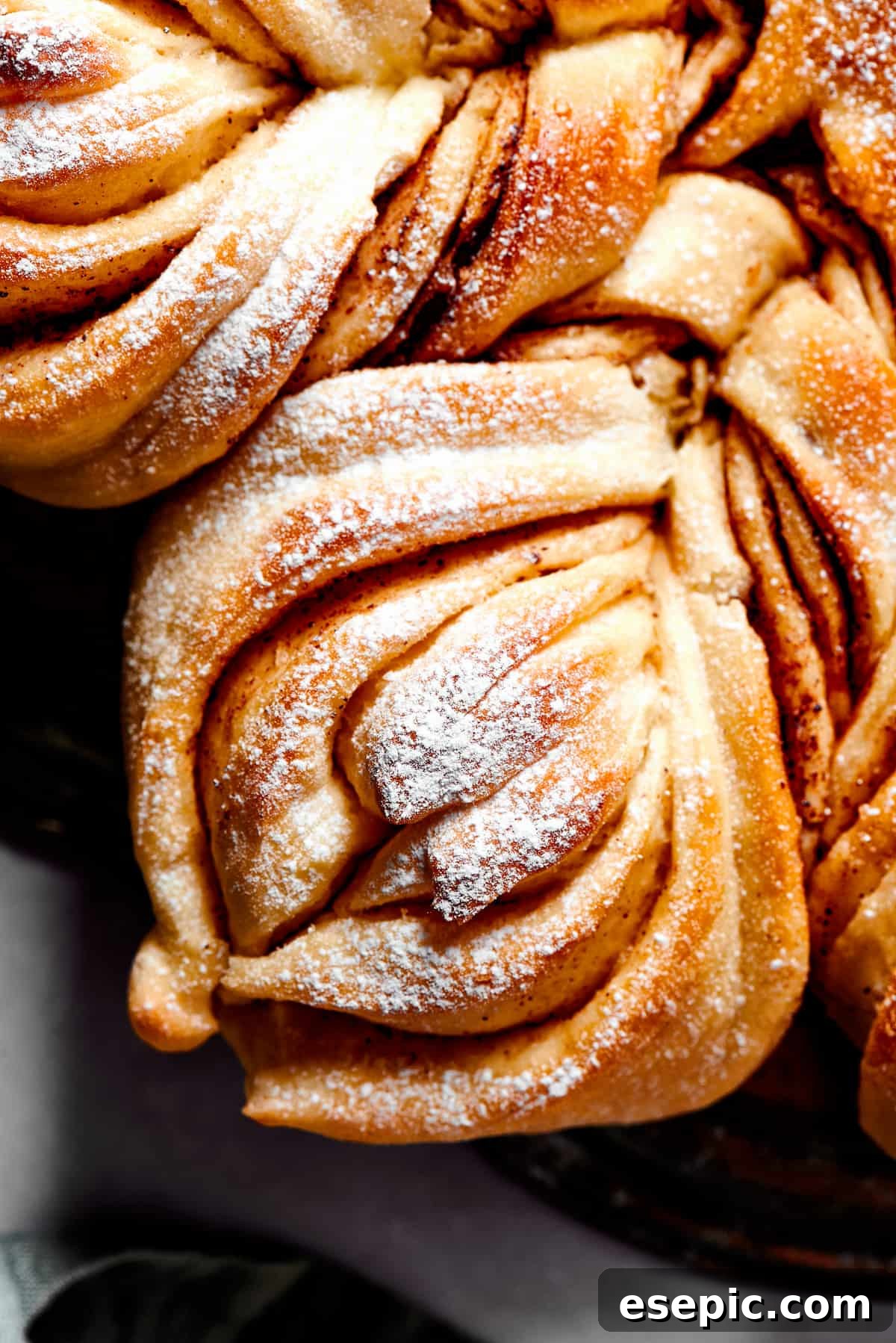 Close up overhead view of one segment of star bread, topped with powdered sugar.