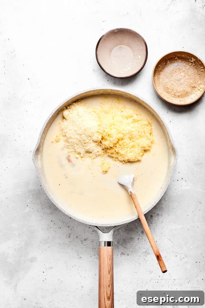 Adding cheese to the sauce base.