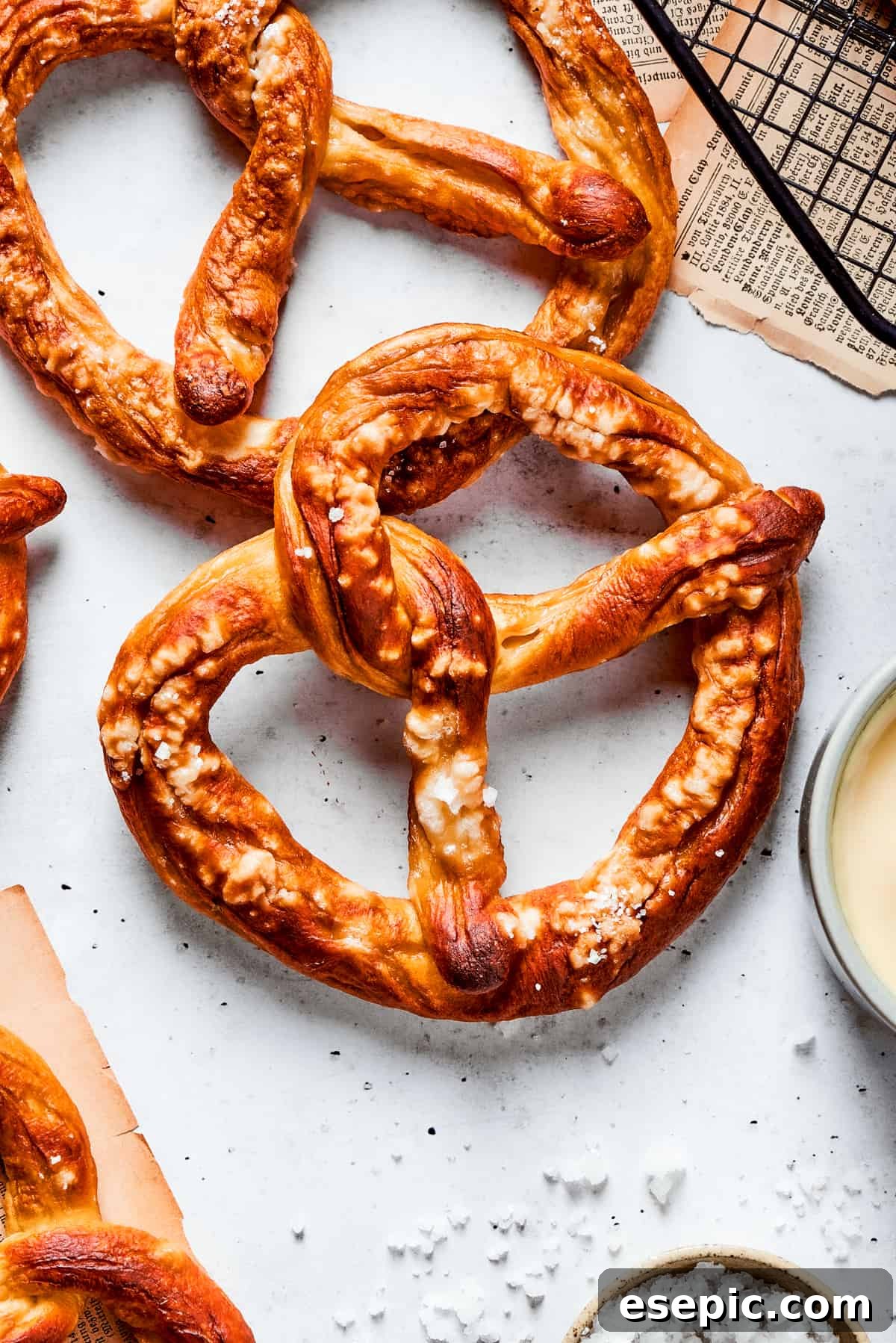 Master the art of homemade soft pretzels and pair them with our decadent, mustard-infused cheese dip. A top down shot of a baked soft pretzel, perfectly golden brown and sprinkled with coarse salt, invitingly placed on a surface.
