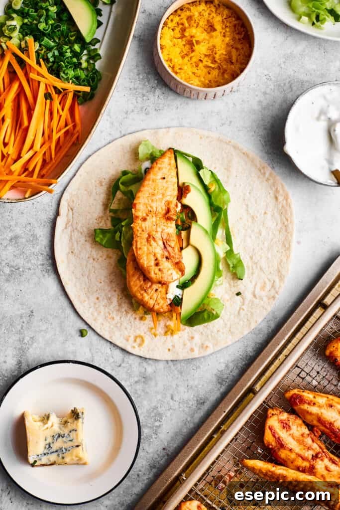 A perfectly seasoned chicken tender being placed onto a bed of fresh vegetables and a warm tortilla, ready to be wrapped.