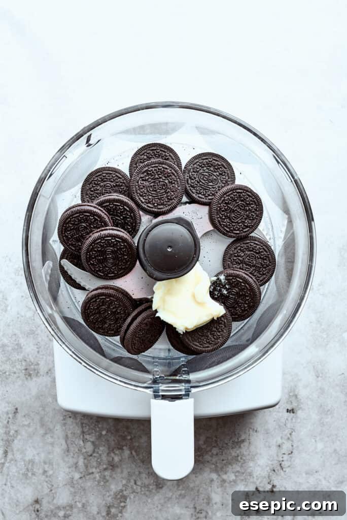 Chocolate cookies are placed in a food processor with a pat of butter.